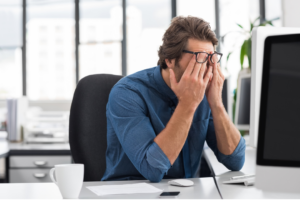 Tired employee with hands on his face